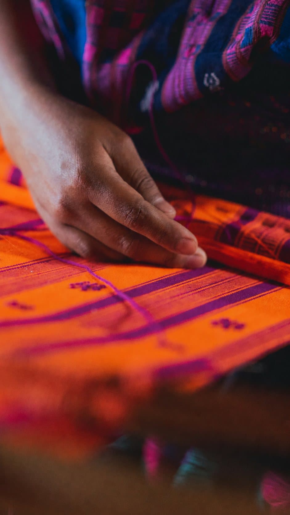 Artisan hands weaving colourful threads